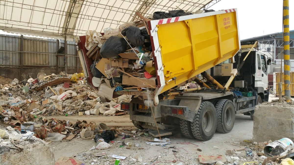 Roll-off truck unloading collected junk and debris